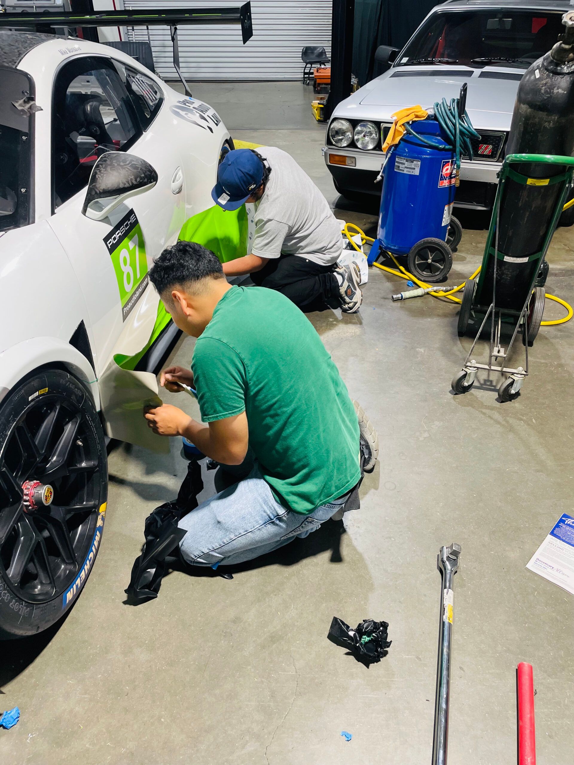 A group of men are working on a car in a garage