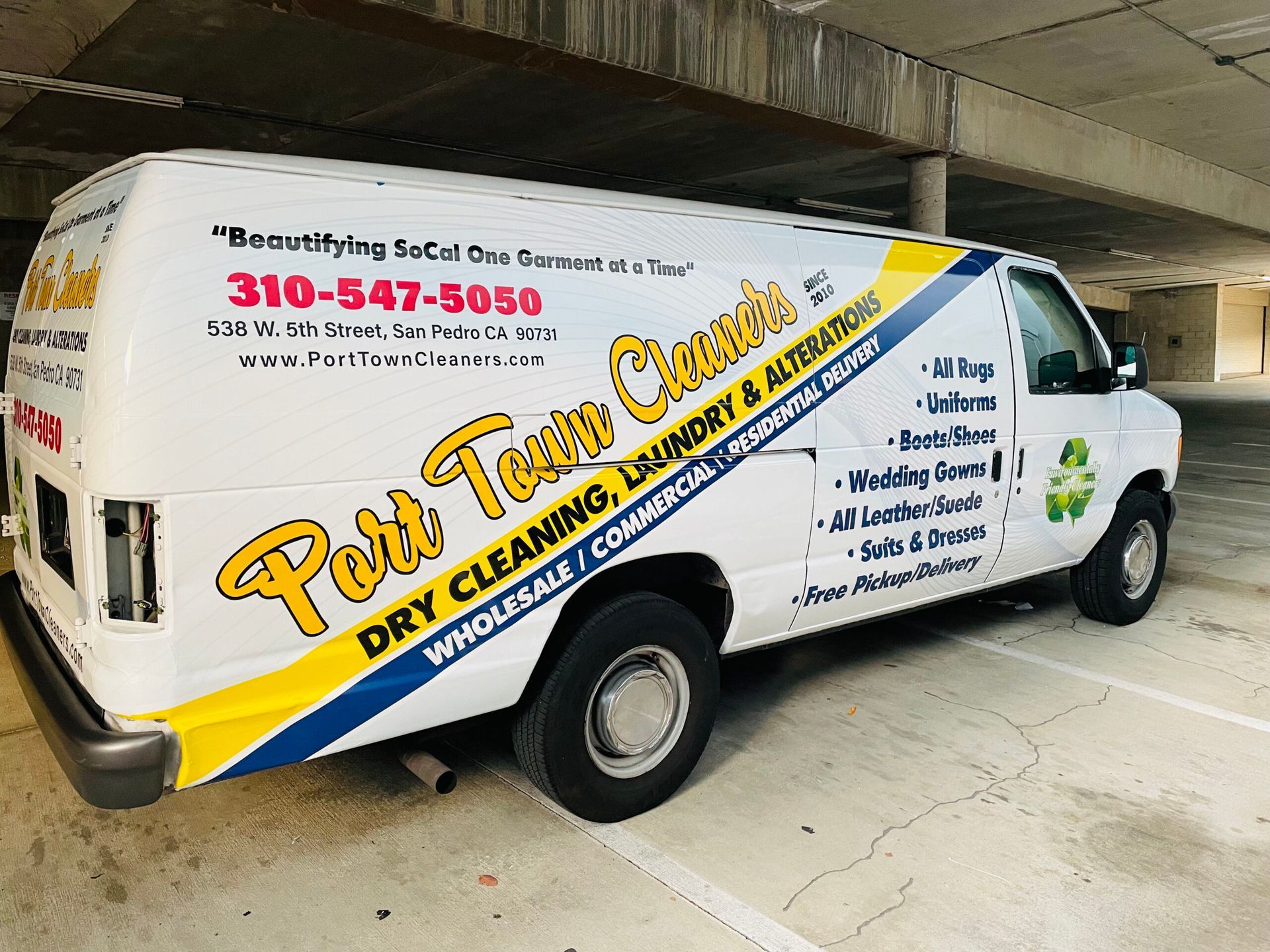 A white van is parked in a parking garage for port town cleaners