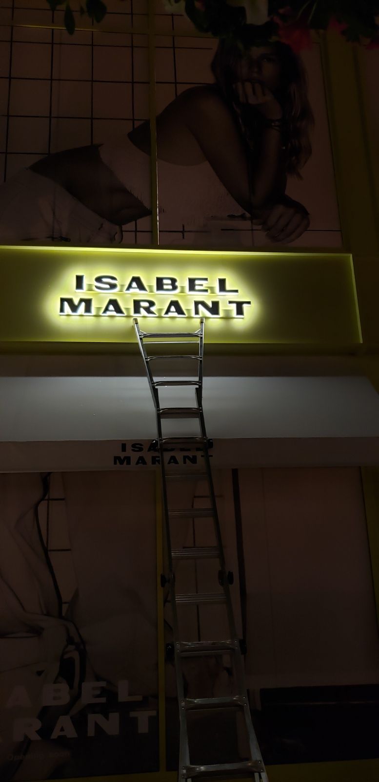 A ladder is going up to a sign that says isabel marant