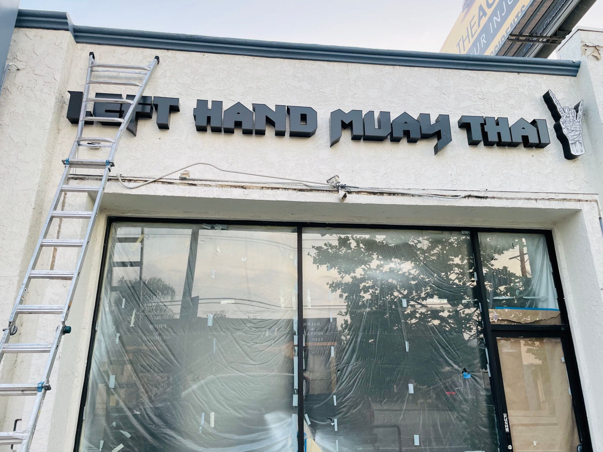 A sign on the side of a building that says left hand muay thai
