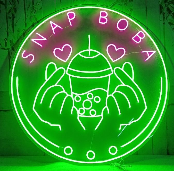 A neon sign for snap boba shows a person holding a cup of drink.
