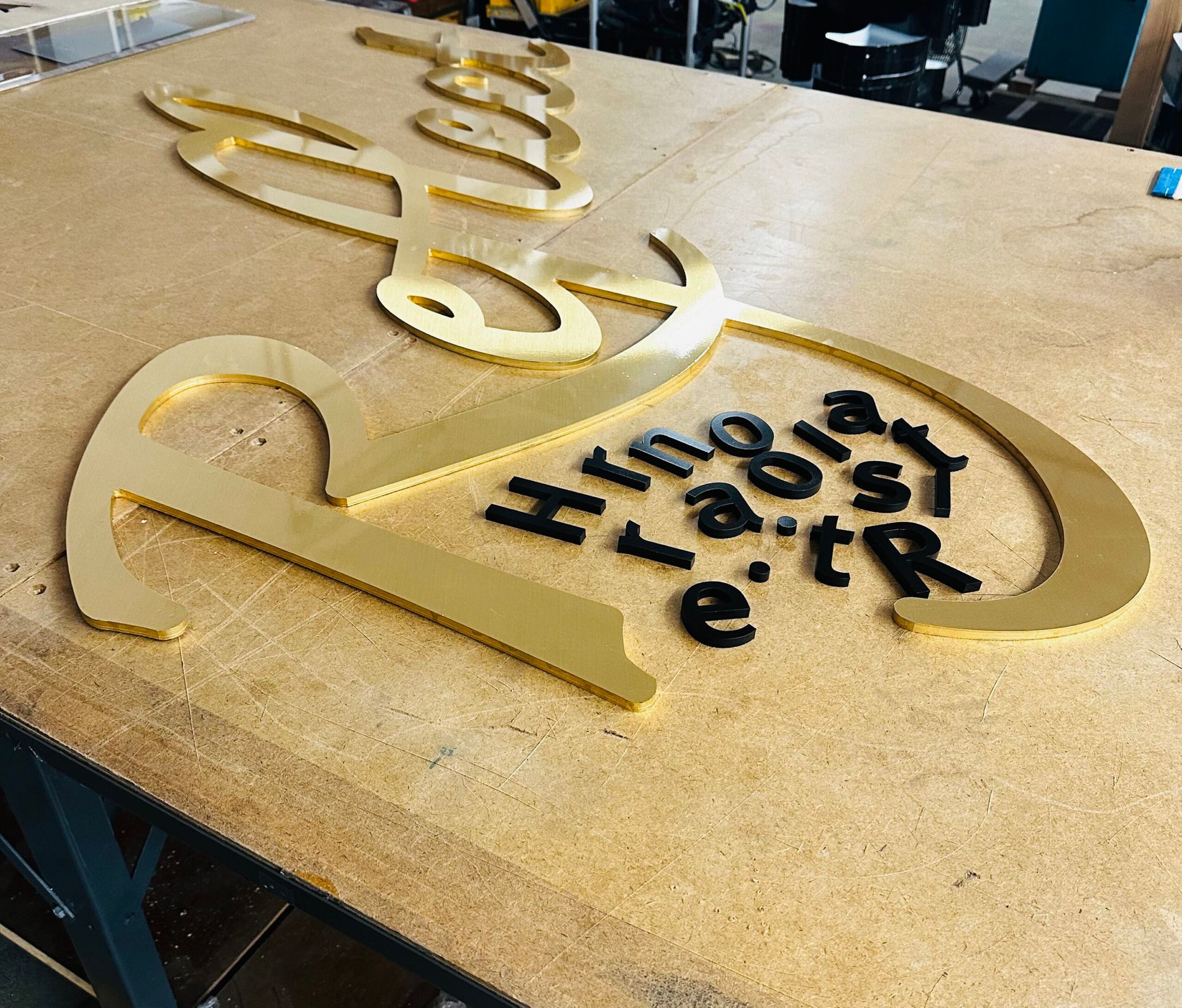 A large gold sign is sitting on top of a wooden table.