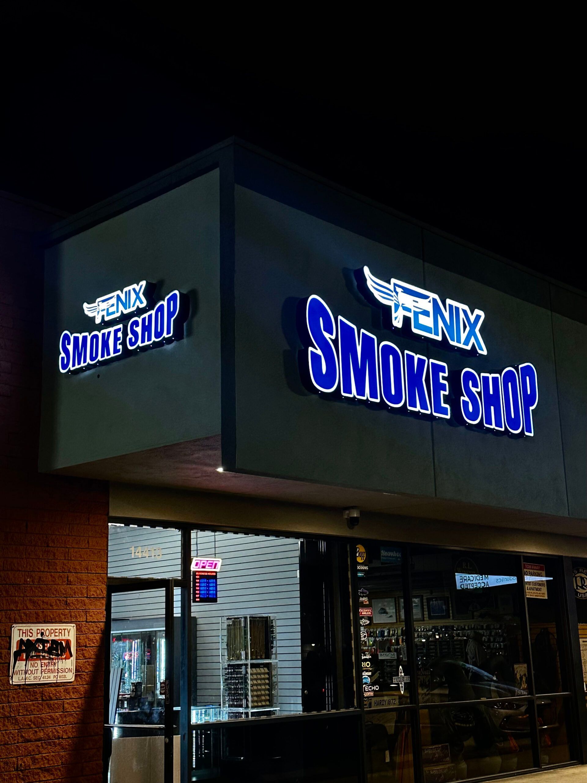 A fenix smoke shop is lit up at night