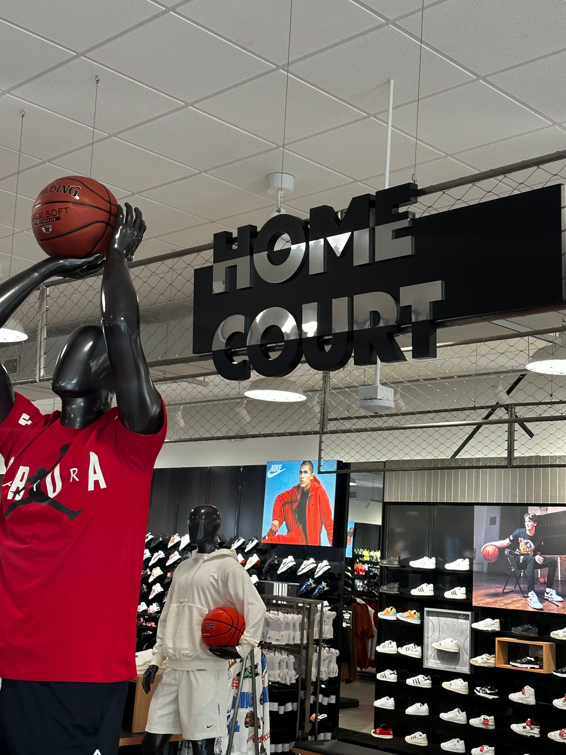 A mannequin is holding a basketball under a sign that says home court
