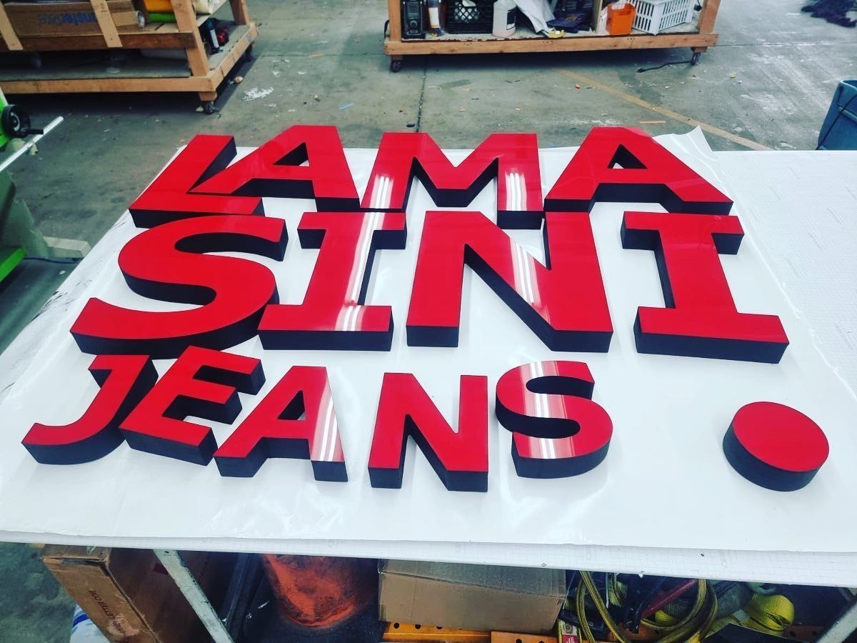 A sign that says ' lama sini jeans ' on it