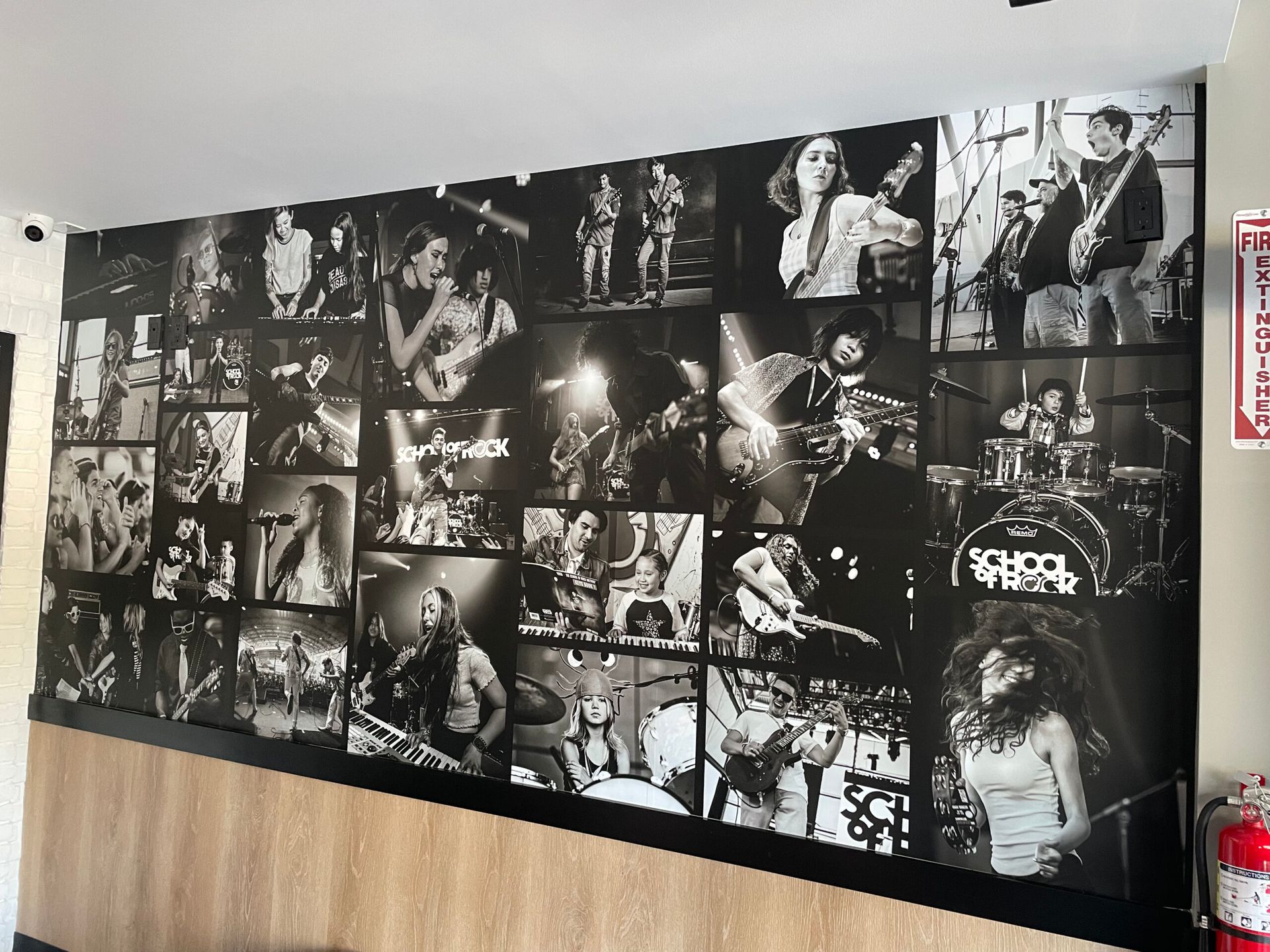 A wall with a lot of black and white photos of people playing instruments