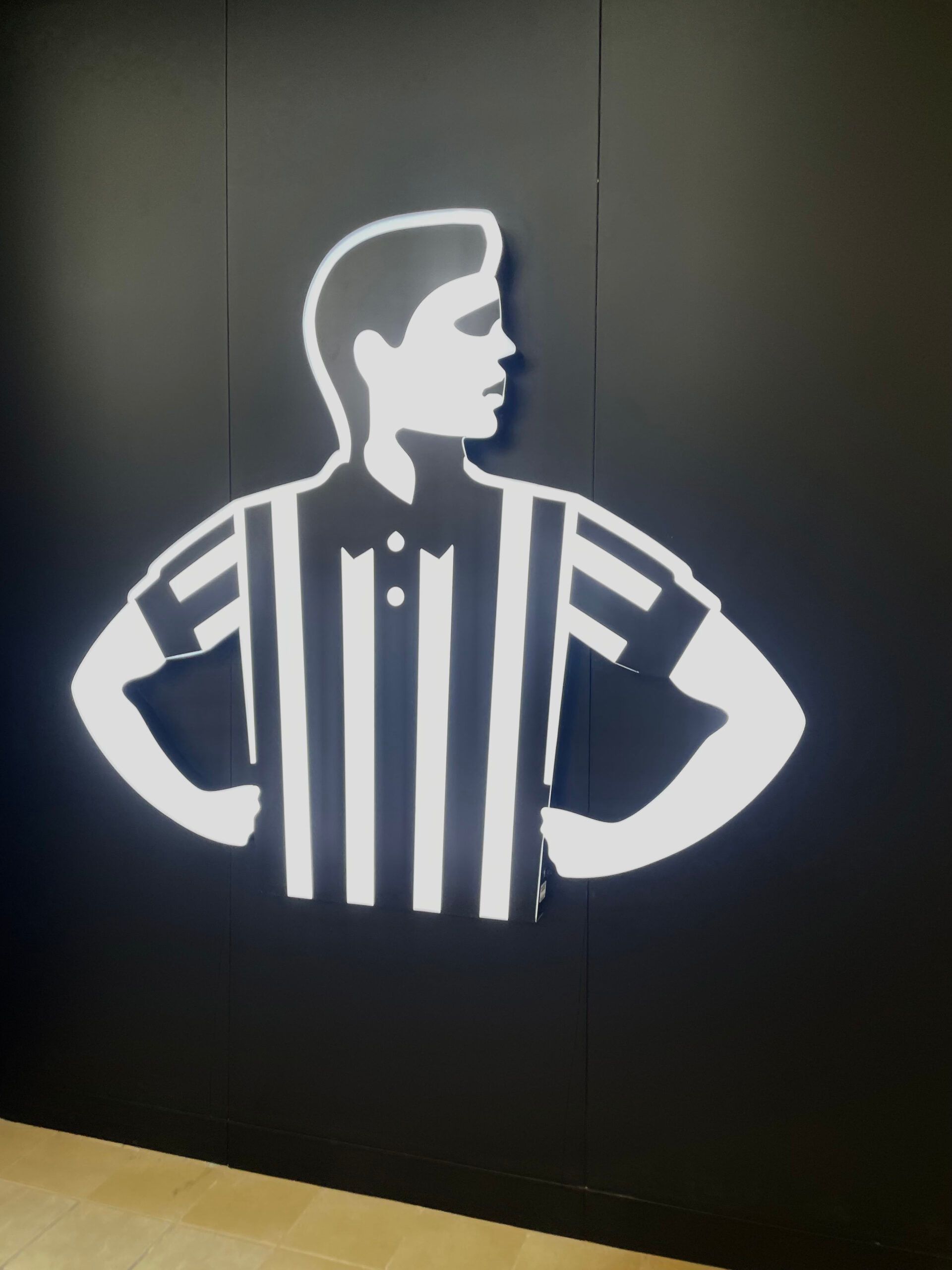 A black and white silhouette of a man with a striped shirt