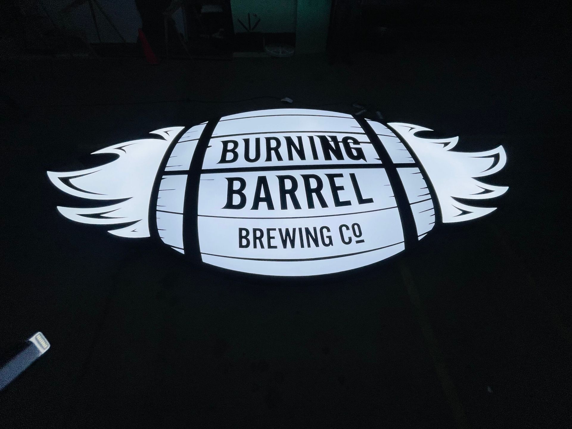 An illuminated barrel-shaped sign reads