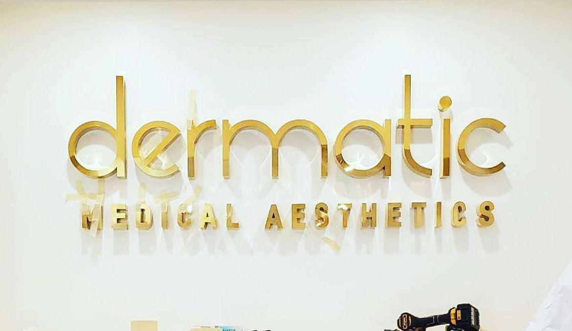 A person is standing in front of a sign that says dermatic medical aesthetics.