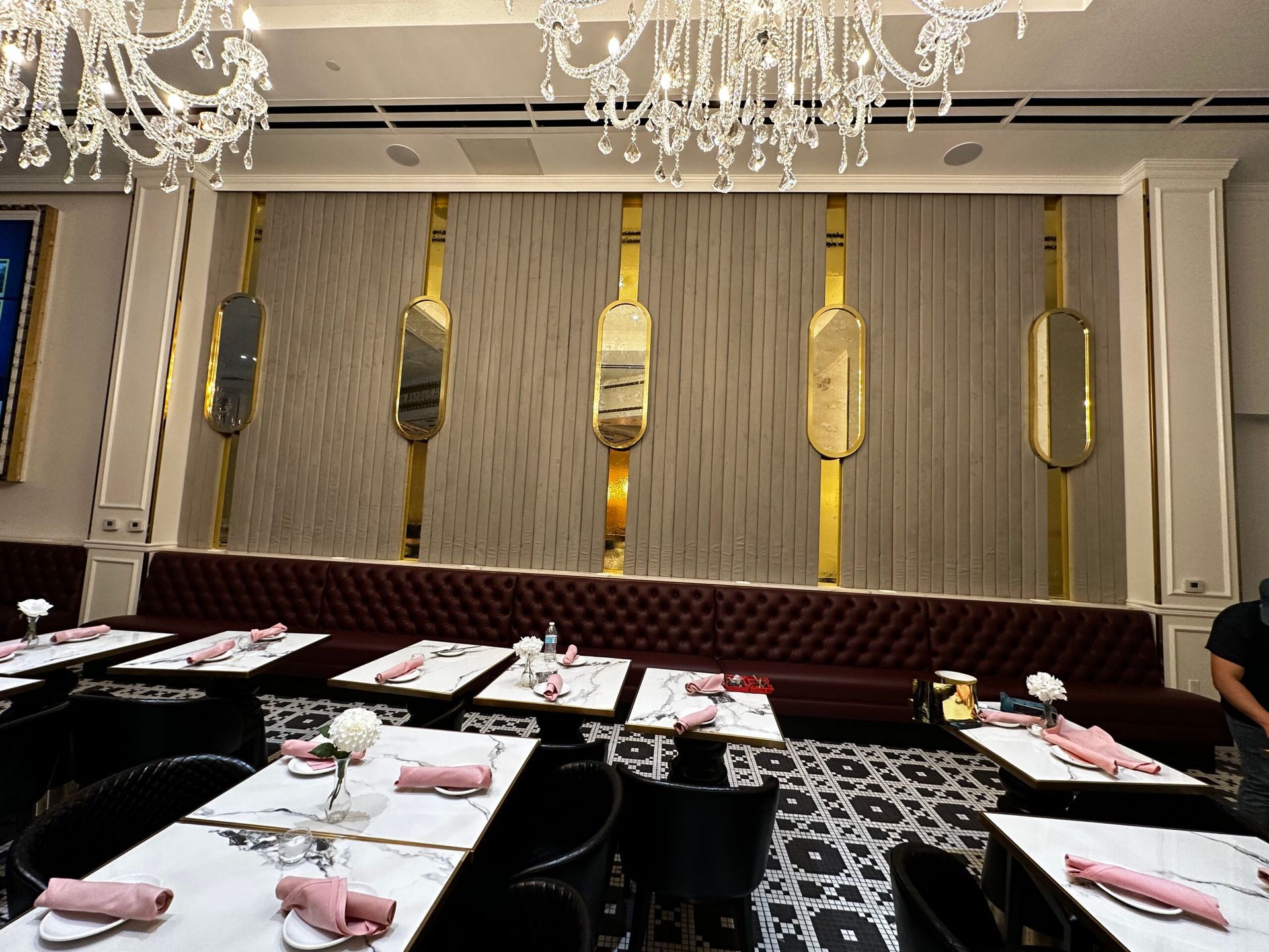 A restaurant with tables and chairs and a chandelier hanging from the ceiling