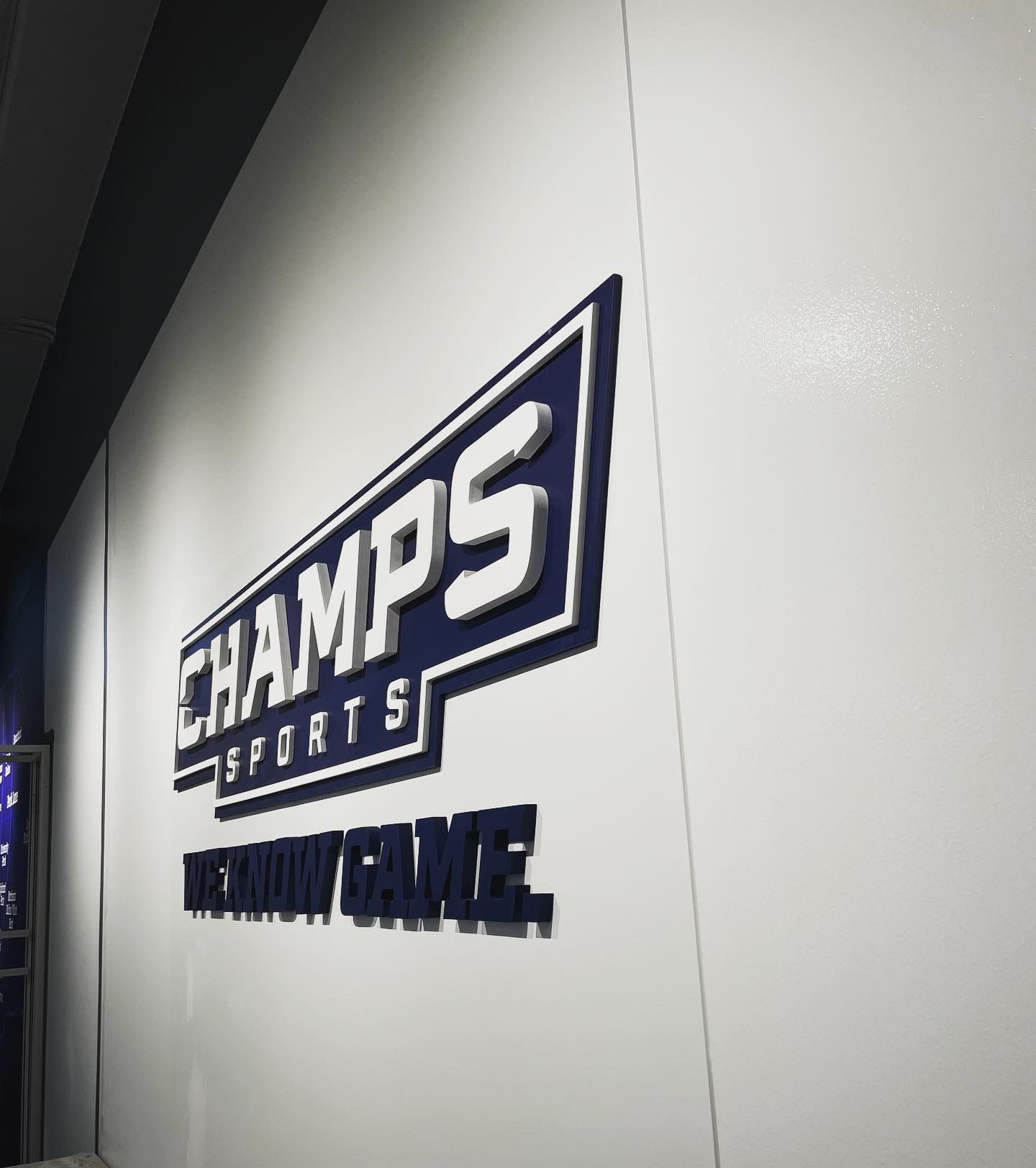 A white wall with champs sports written on it
