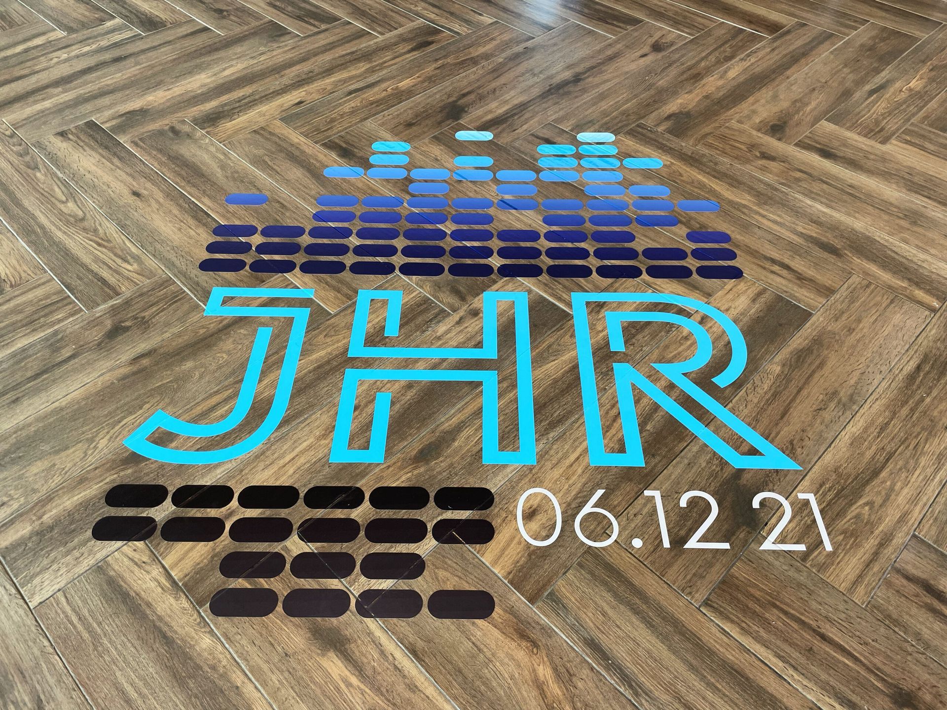 A logo on a wooden floor that says jhr