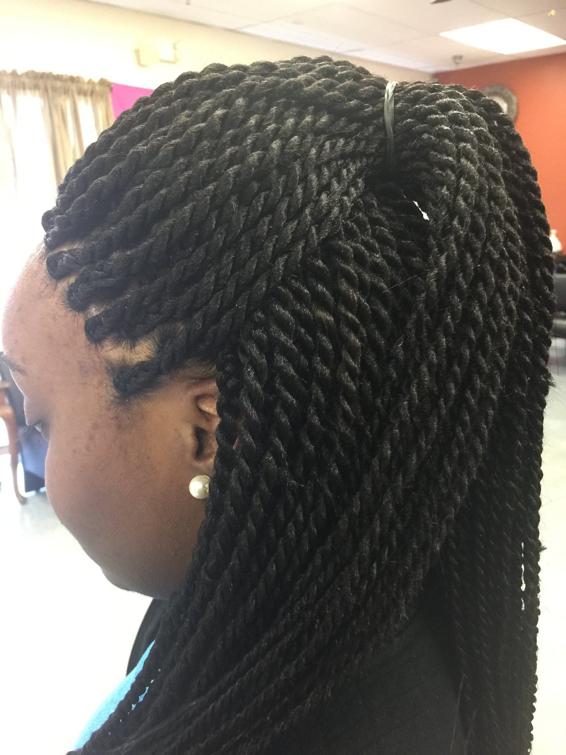 Woman with black twists hairstyle, parted to the side, indoors.