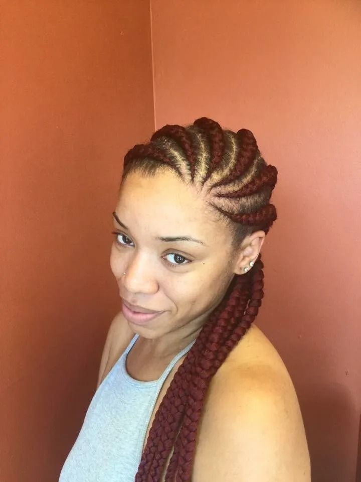 Woman with burgundy cornrow braids styled to the side, wearing a gray tank top.
