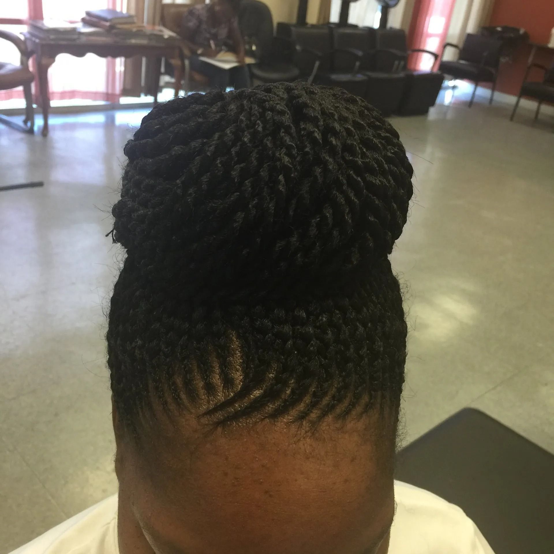 Woman with braided updo hairstyle in a salon.