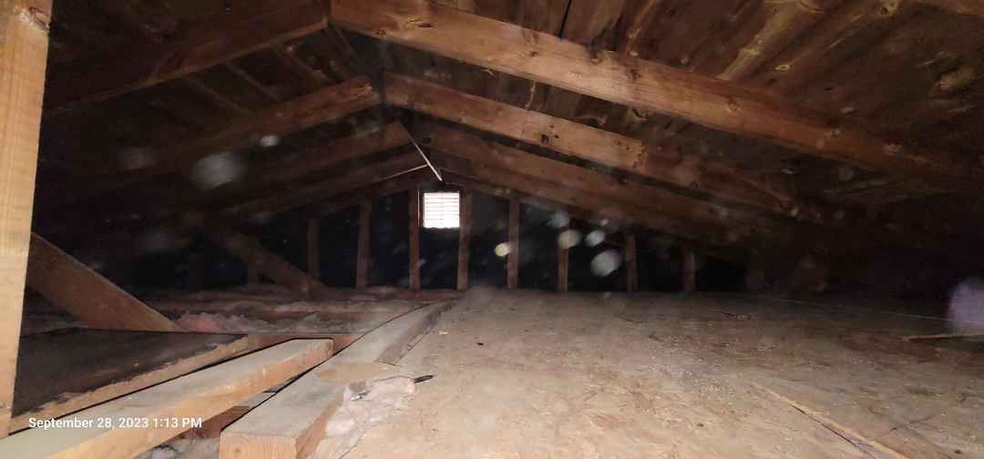 An attic with a wooden floor and a wooden roof.