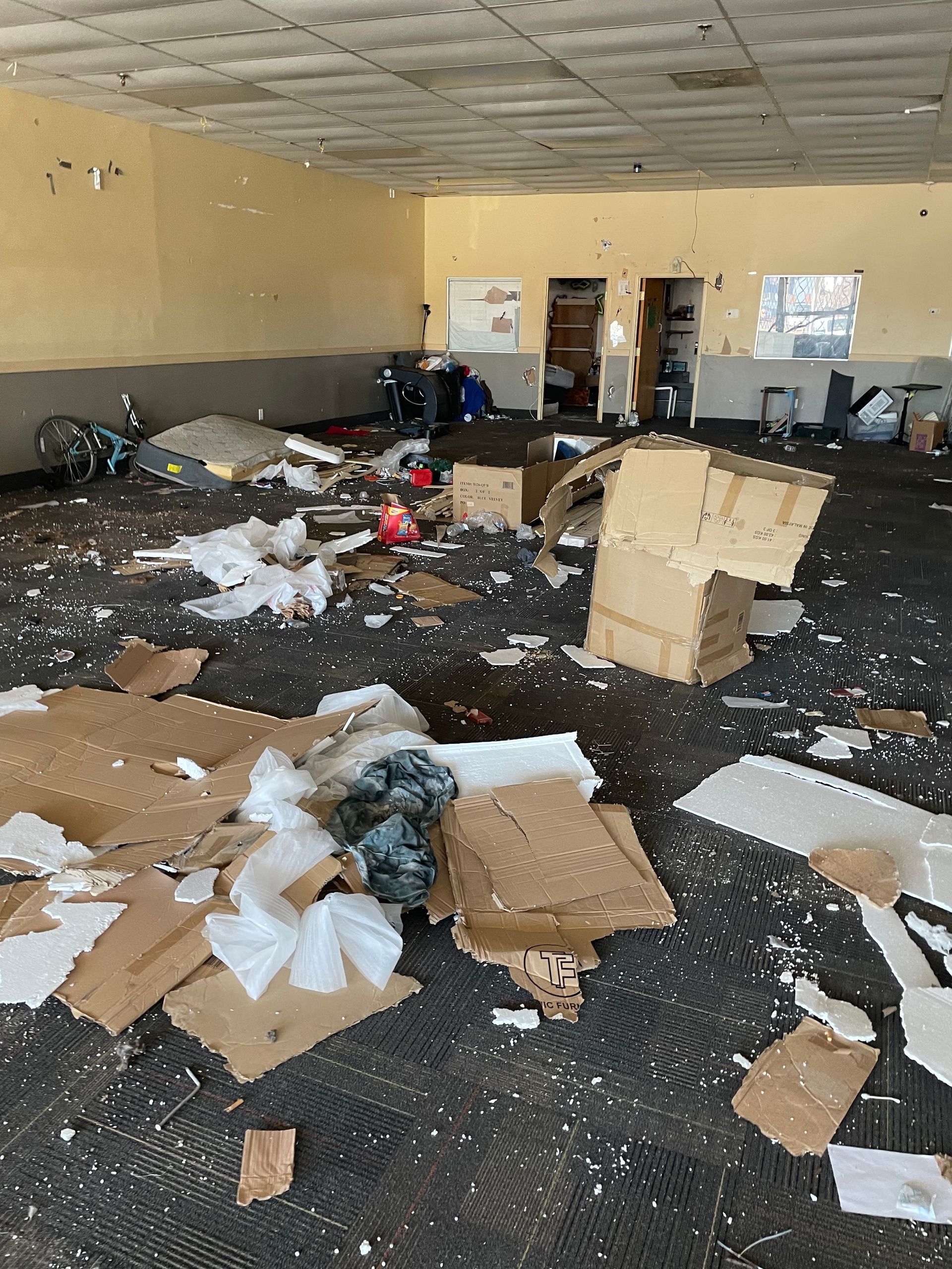 A room with a lot of cardboard boxes on the floor.