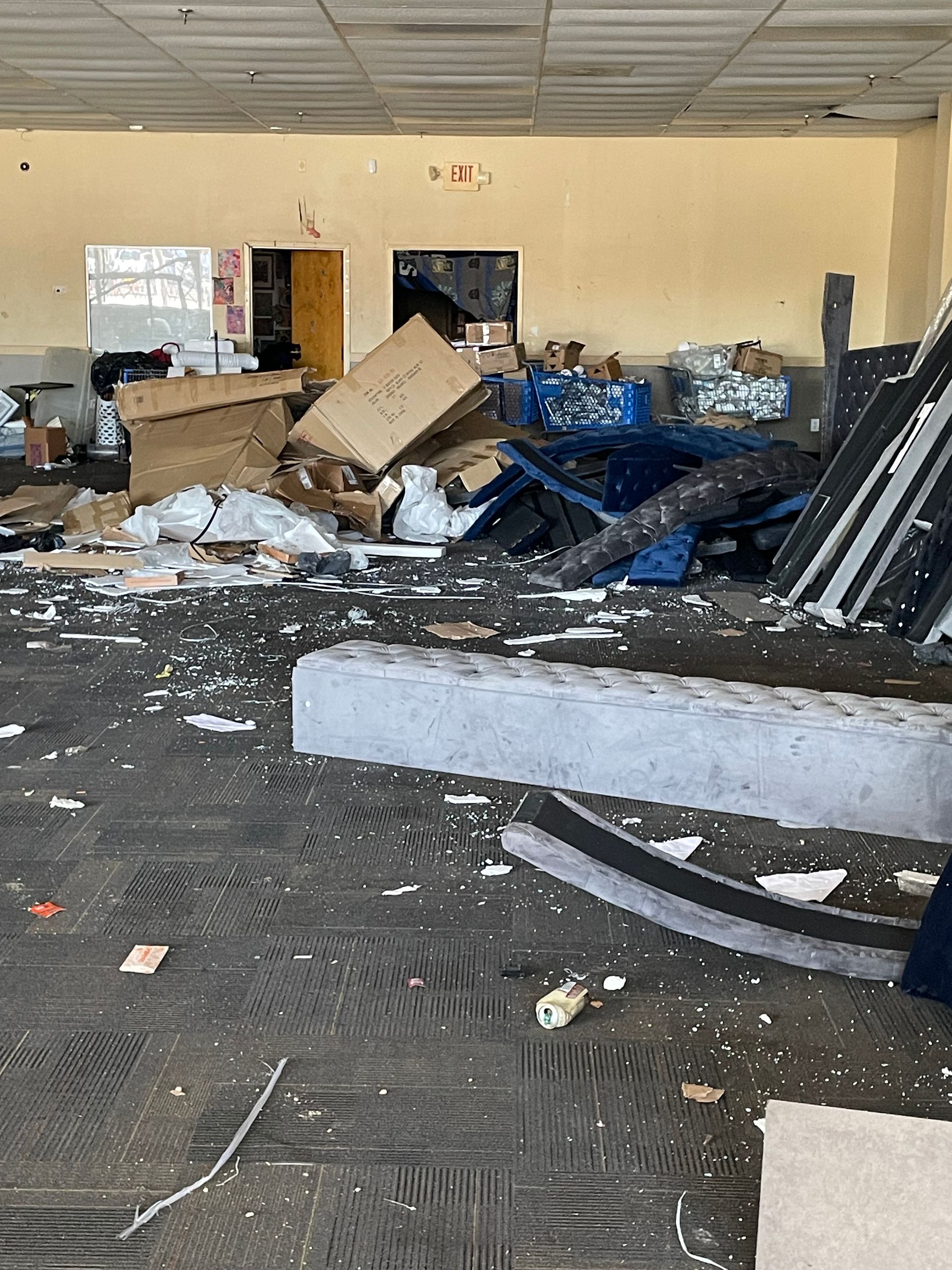 An empty room with a lot of trash on the floor.