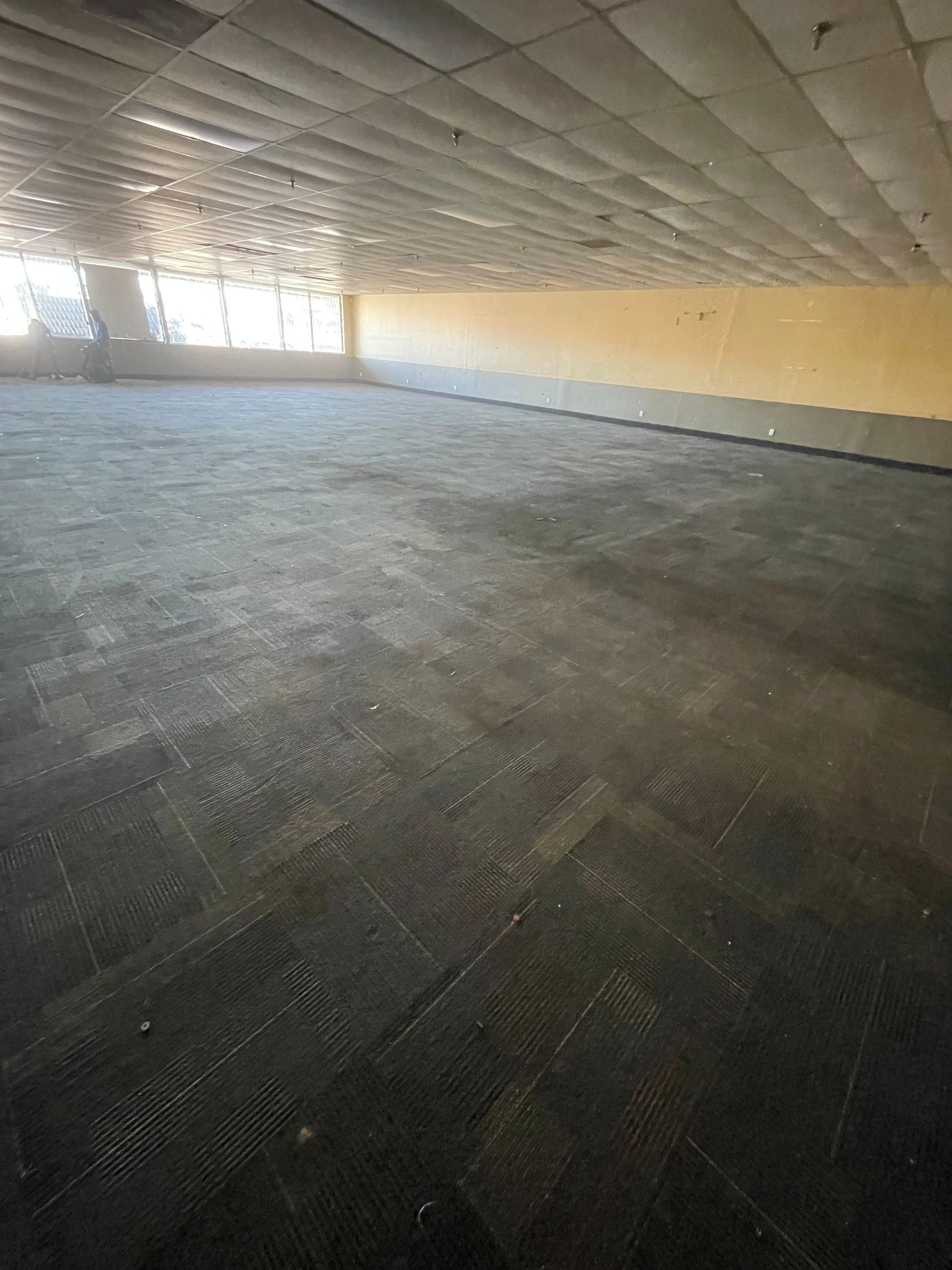 A large empty room with a tiled floor and a ceiling.