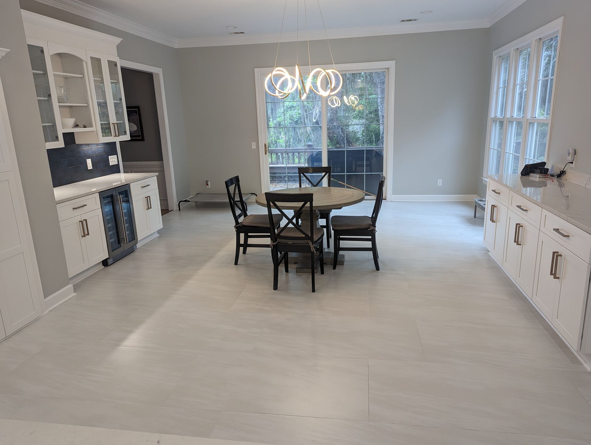 Dining room with a round table, chairs, bar area, and large windows.