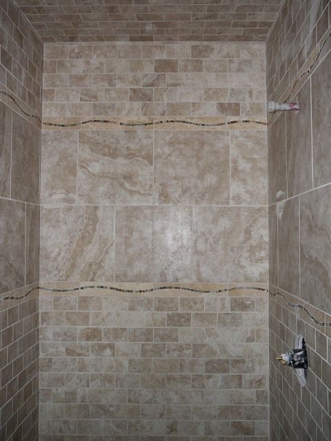 Tan tiled shower with decorative wave tile lines.