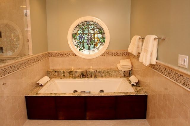 Bathroom with a built-in tub, a stained-glass window, and pale green walls.