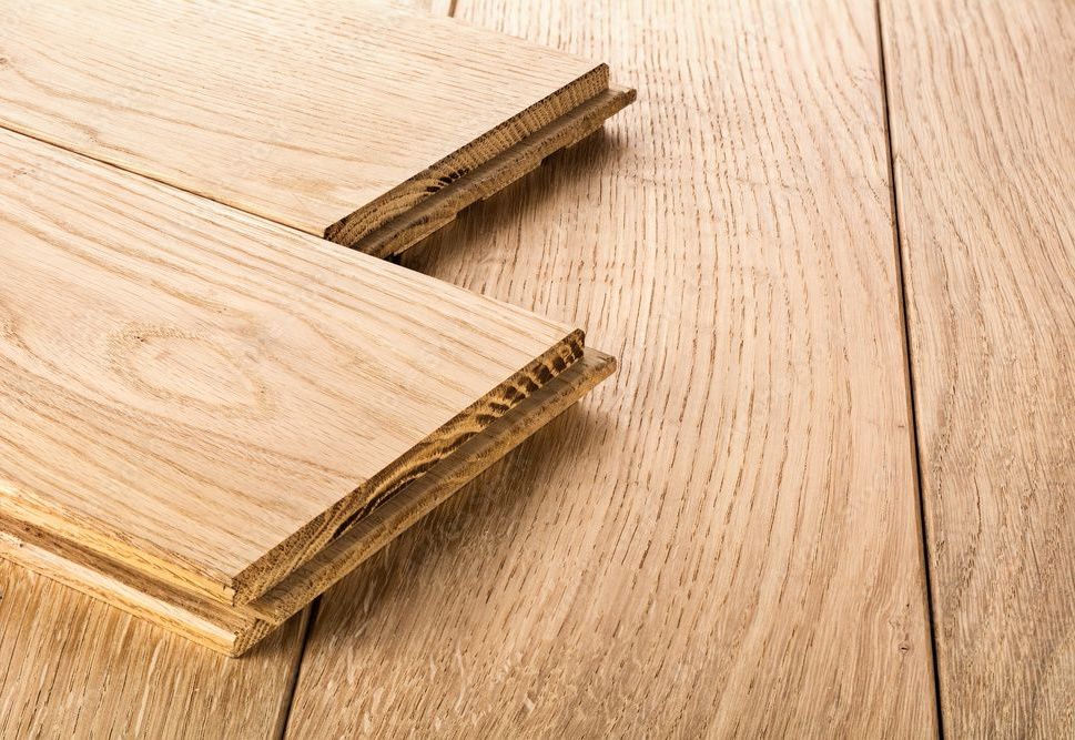 Two pieces of wood are stacked on top of each other on a wooden floor.