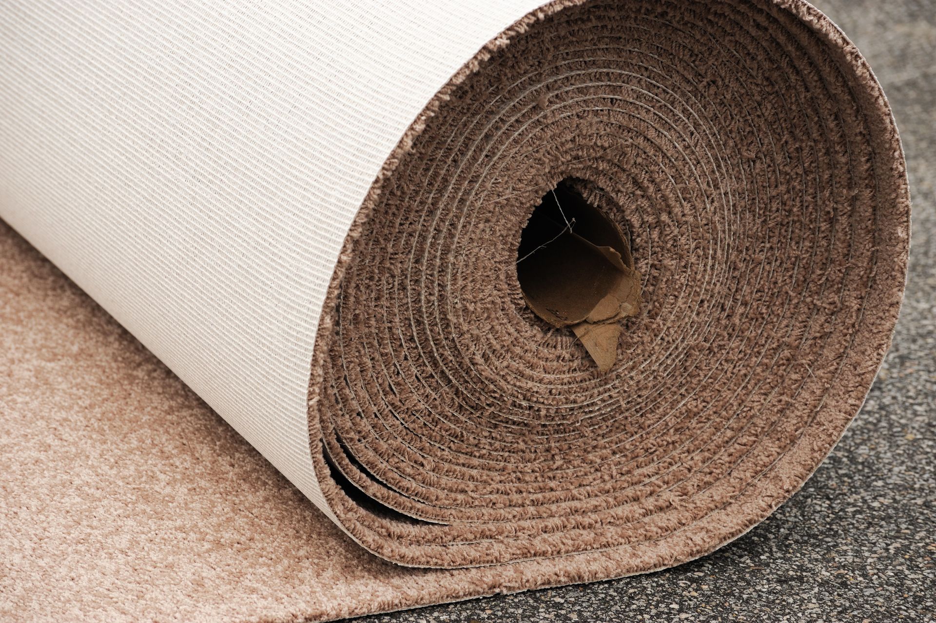 A roll of carpet is sitting on the ground.