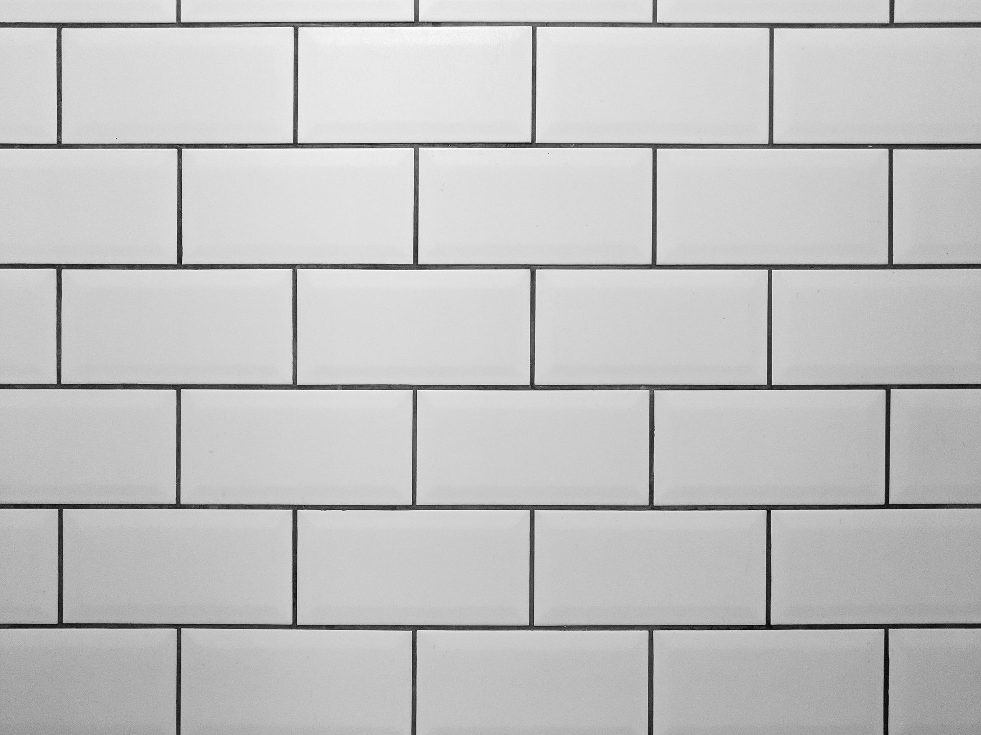 A close up of a white subway tile wall.