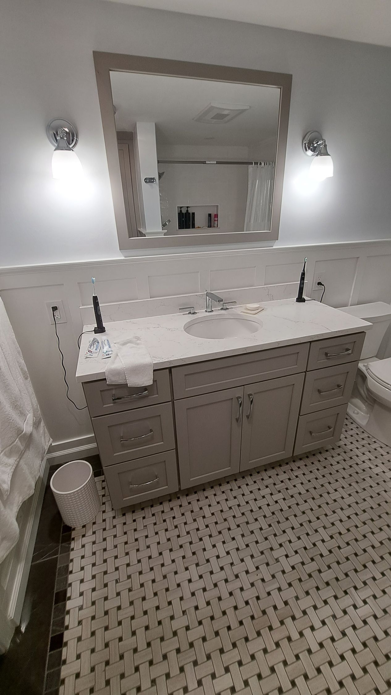A bathroom with two sinks, a toilet, and a large mirror.