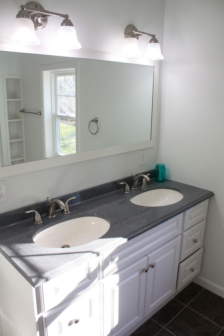 A bathroom with two sinks and a large mirror