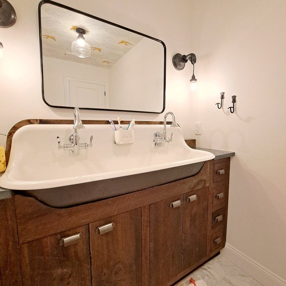 A bathroom with a large sink and a mirror.