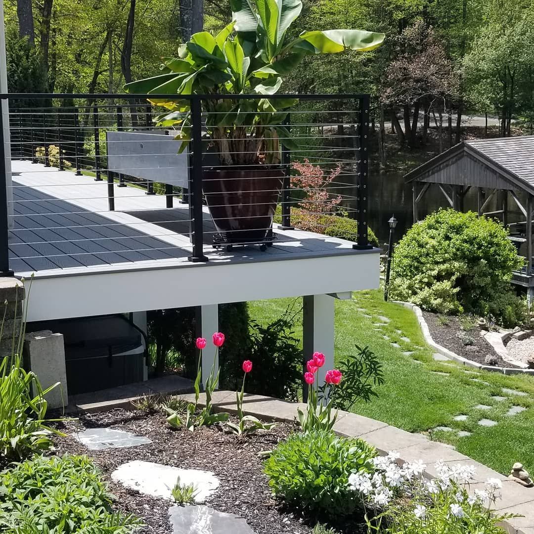 A deck with a potted plant on it in a garden.
