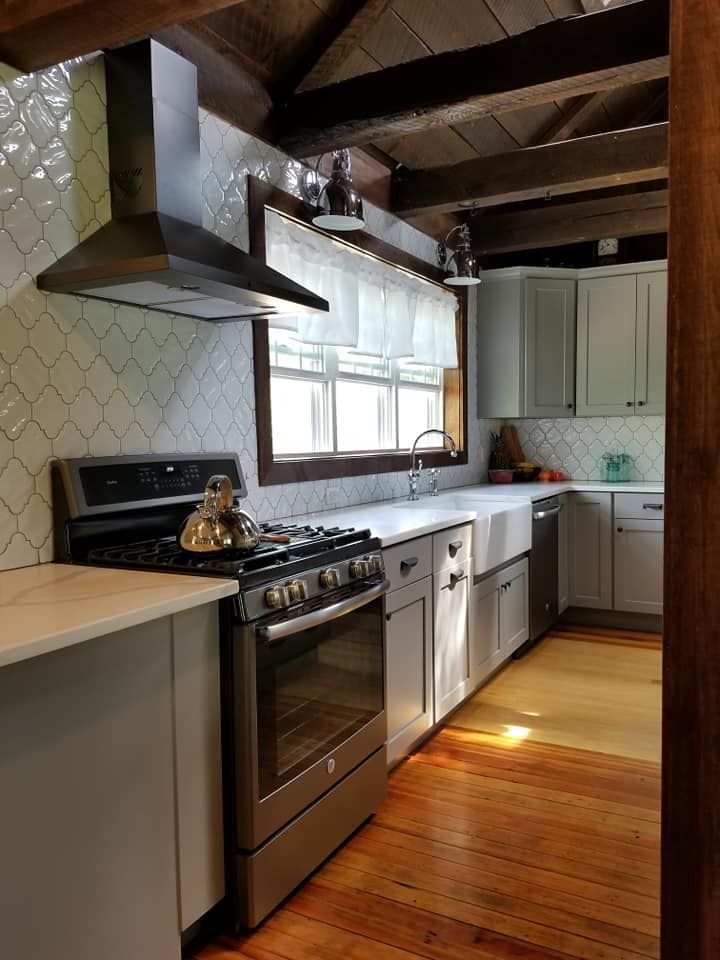 A kitchen with stainless steel appliances and wooden floors.
