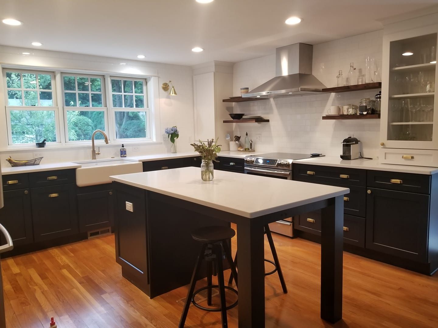 A kitchen with black cabinets and white counter tops