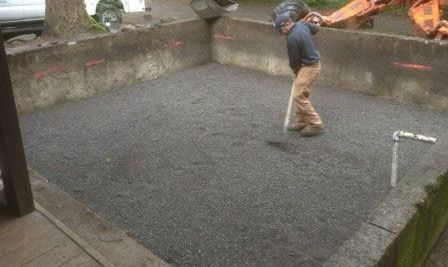 A man is shoveling gravel into a pool.