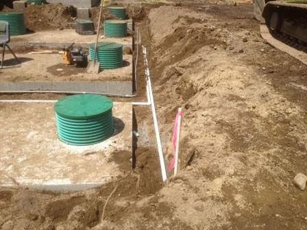 A construction site with a lot of dirt and a green tank in the middle of it.