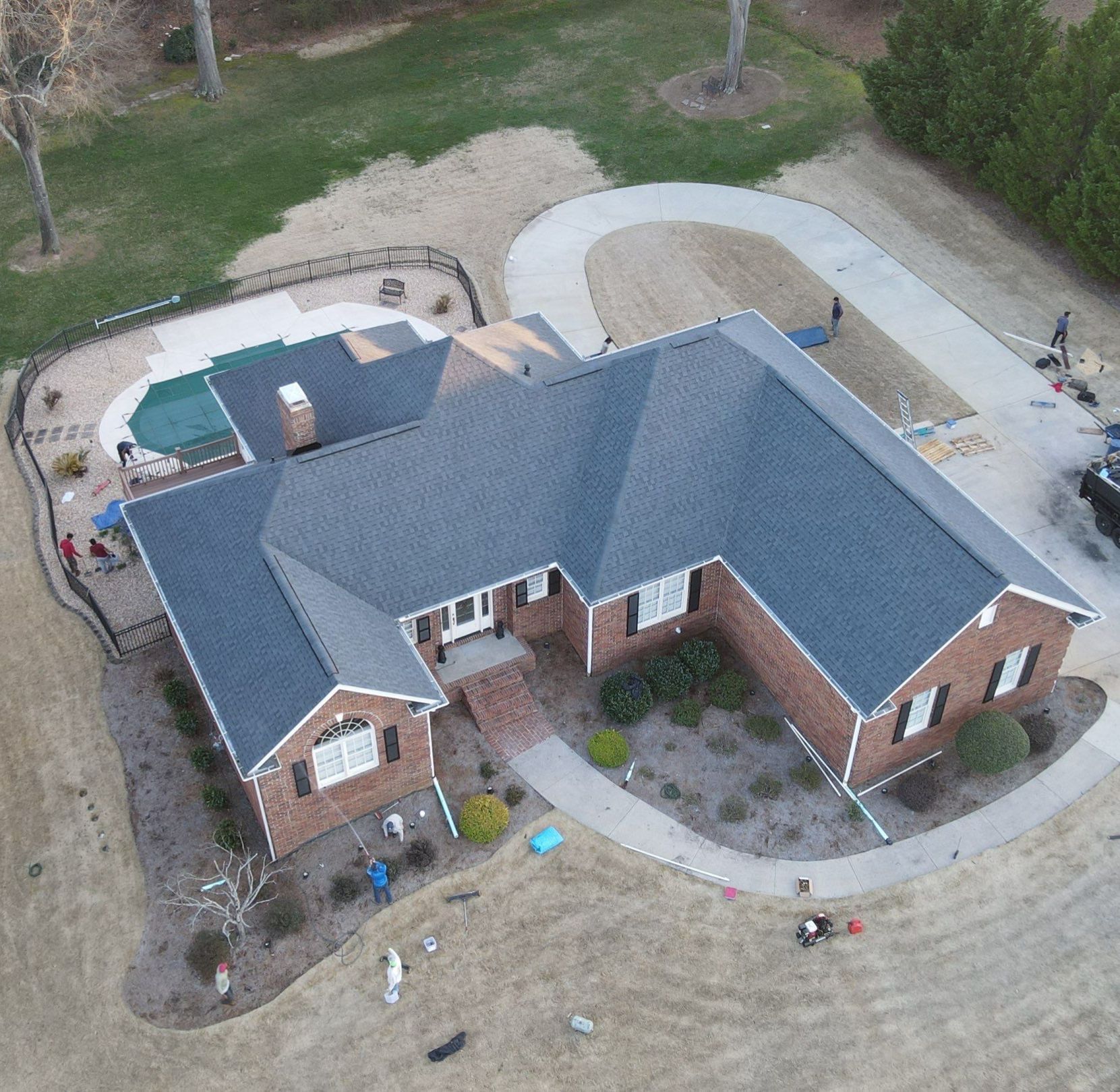 An aerial view of a brick house with a blue roof