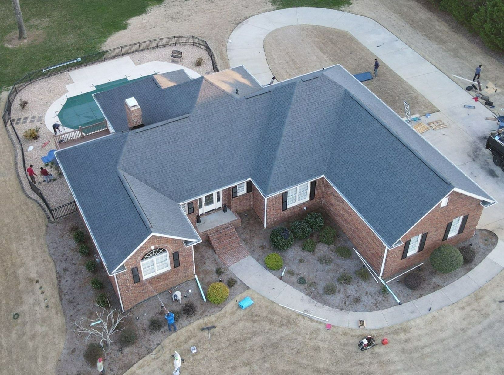 An aerial view of a brick house with a blue roof