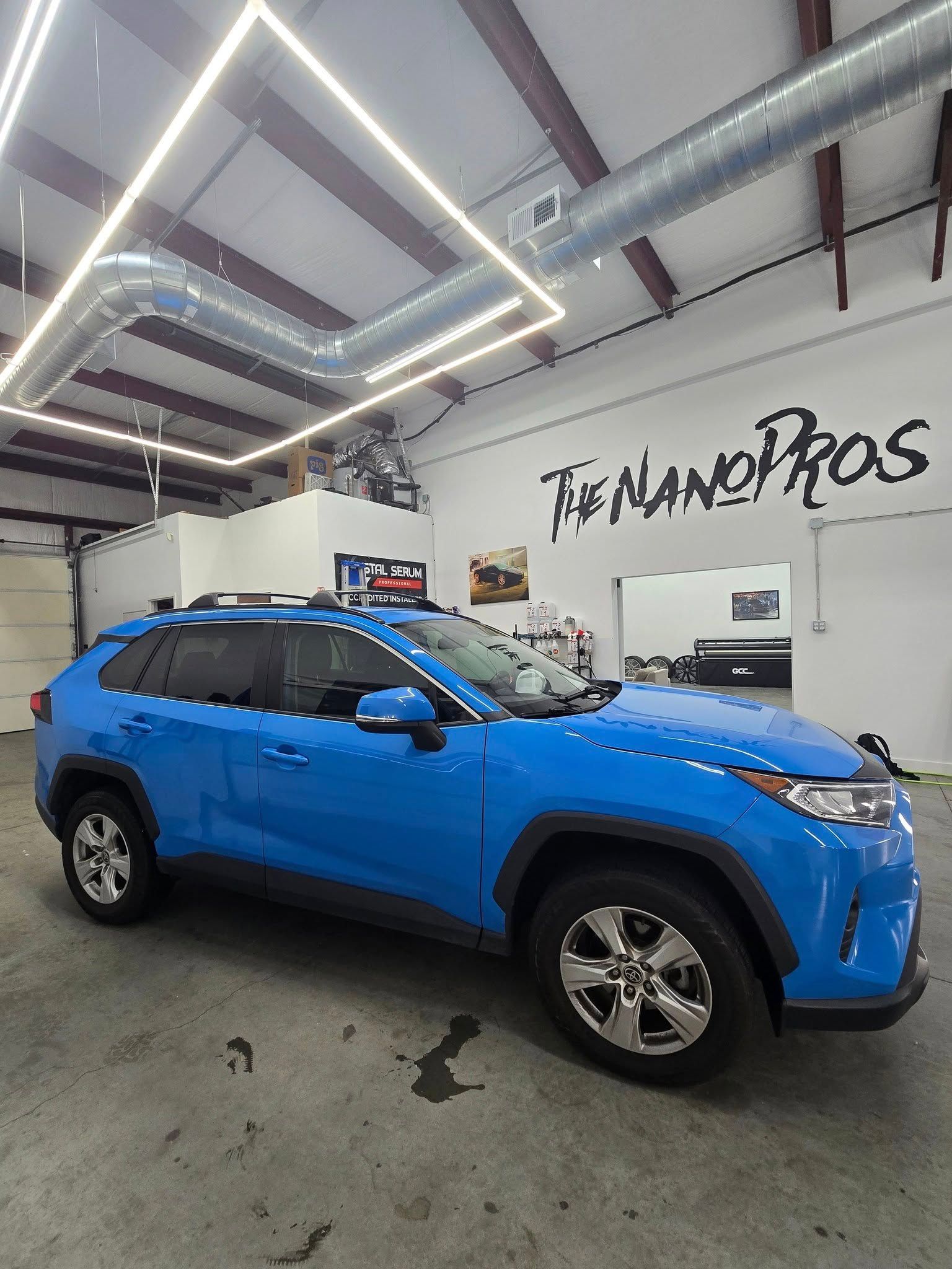 A blue toyota rav4 is parked in a garage.