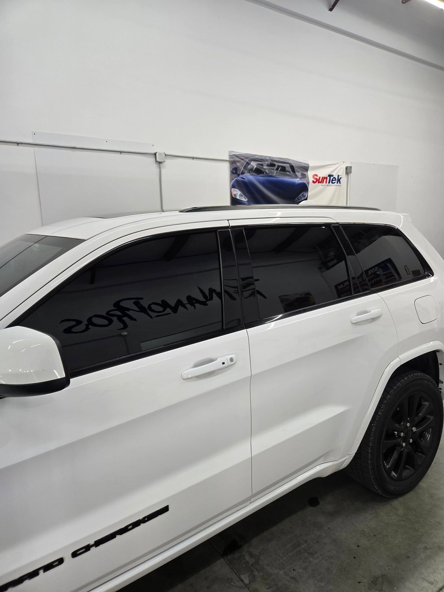 A white jeep grand cherokee is parked in a garage.