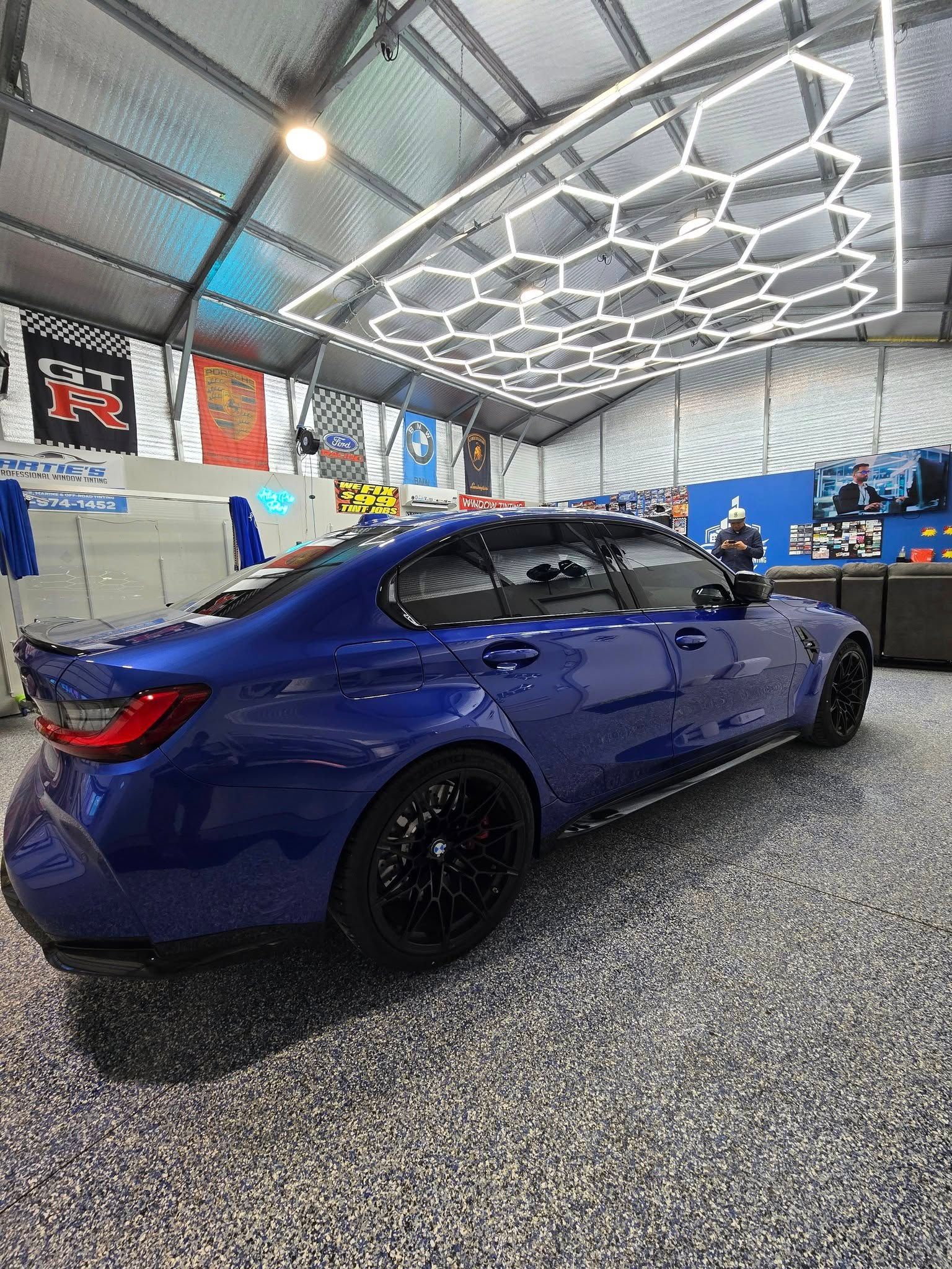 A blue bmw m3 is parked in a garage.