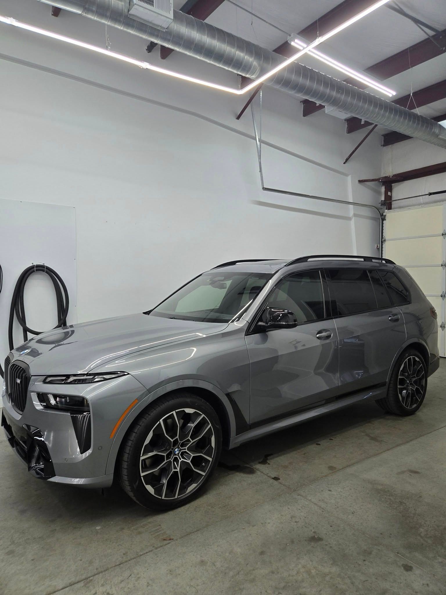 A bmw x7 is parked in a garage.