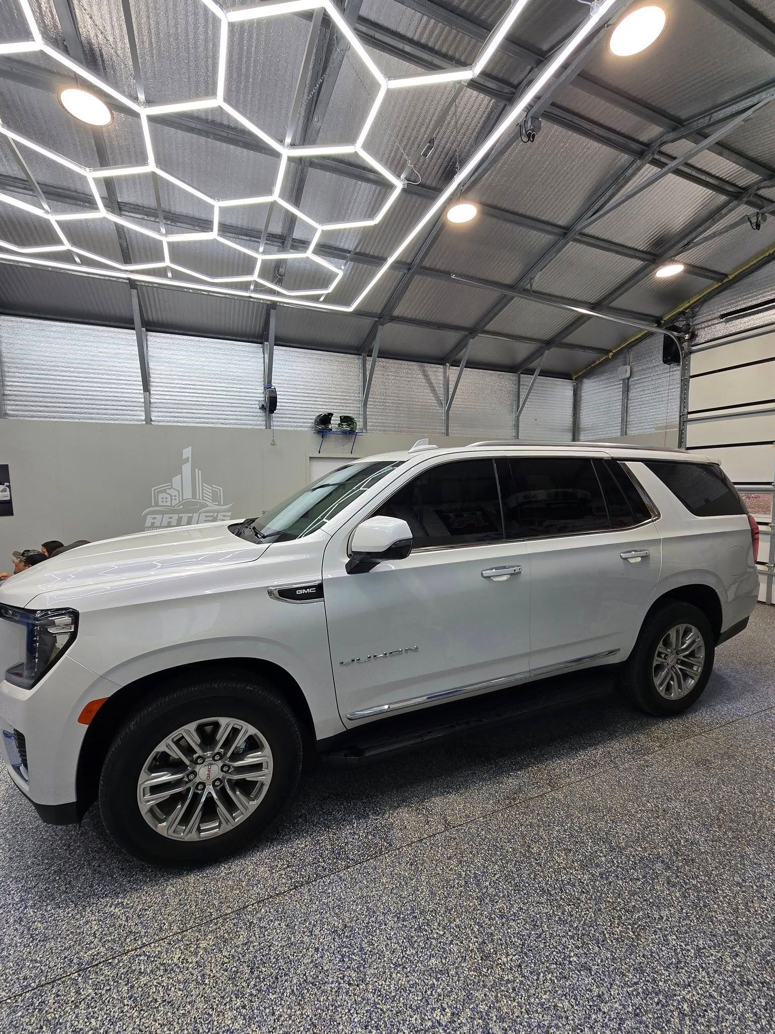 A white suv is parked in a garage.
