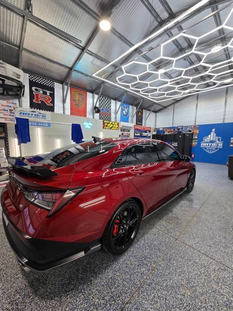 A red car is parked in a garage.