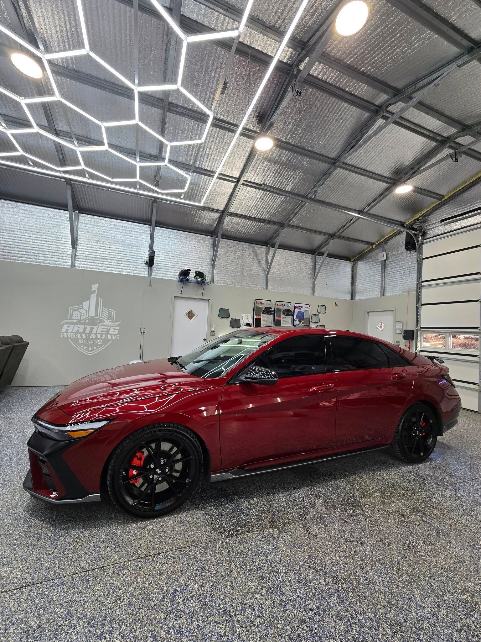 A red car is parked in a garage.