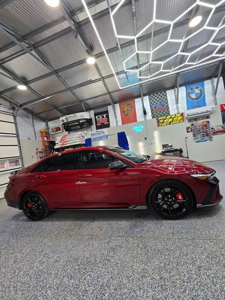A red car is parked in a garage.