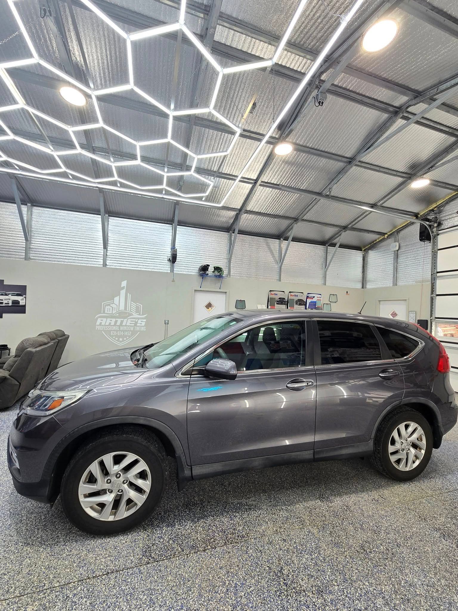 A gray honda cr v is parked in a garage.