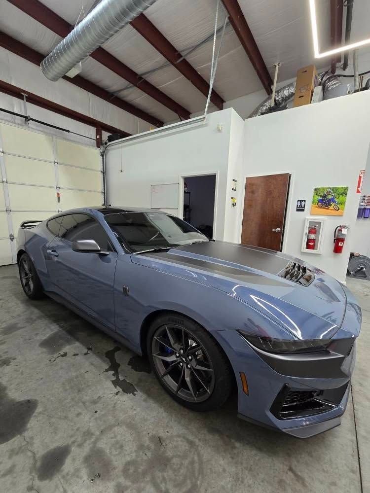 A blue sports car is parked in a garage.
