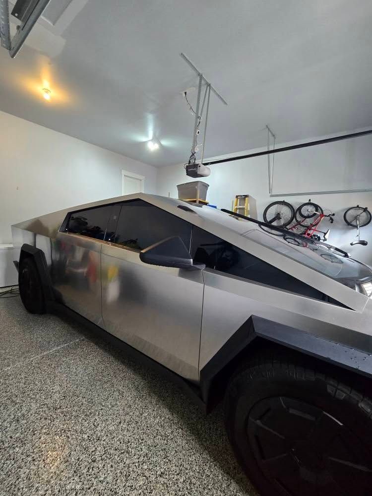 A tesla cybertruck is parked in a garage.